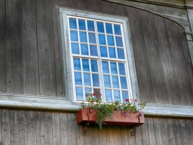 Großes Fenster mit Blumen Holzfassade