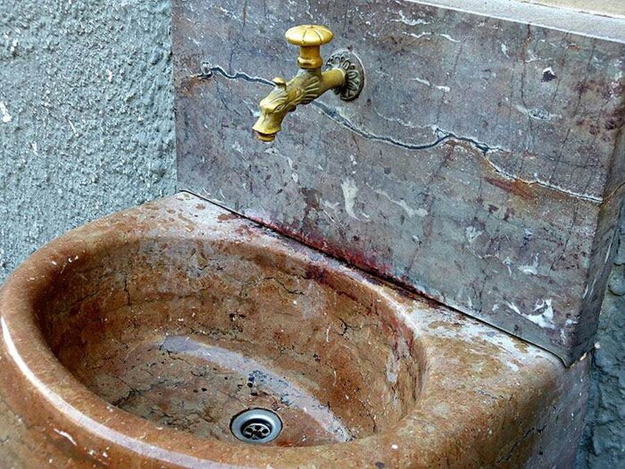 Waschbecken Stein goldener Wasserhahn