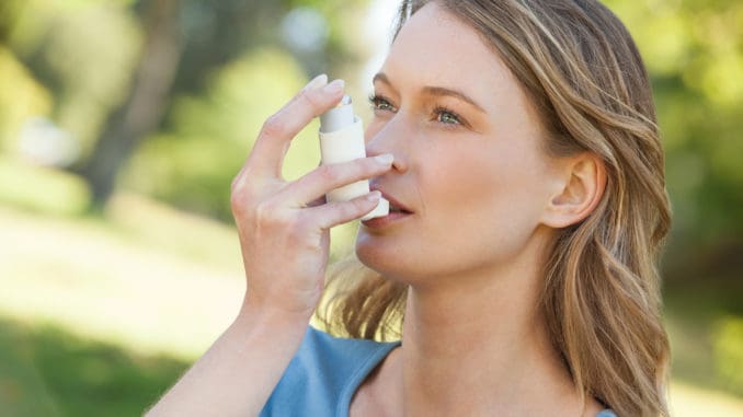 Frau mit Asthma-Inhalator im Park Frau mit Asthma-Inhalator im Park
