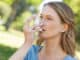 Frau mit Asthma-Inhalator im Park